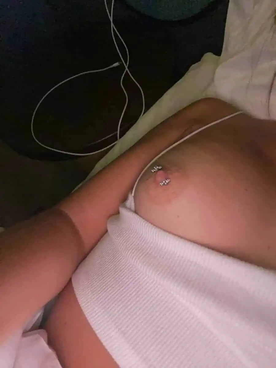 woman shows her nipple with a piercing